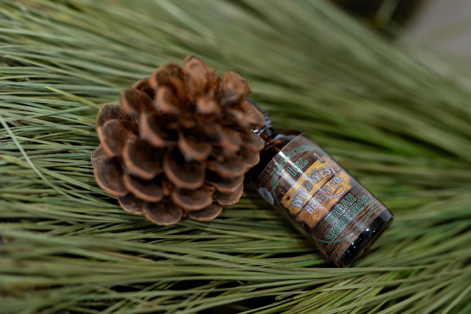 A picture of Urban Woodsman platinum Beard Oil on pine needles